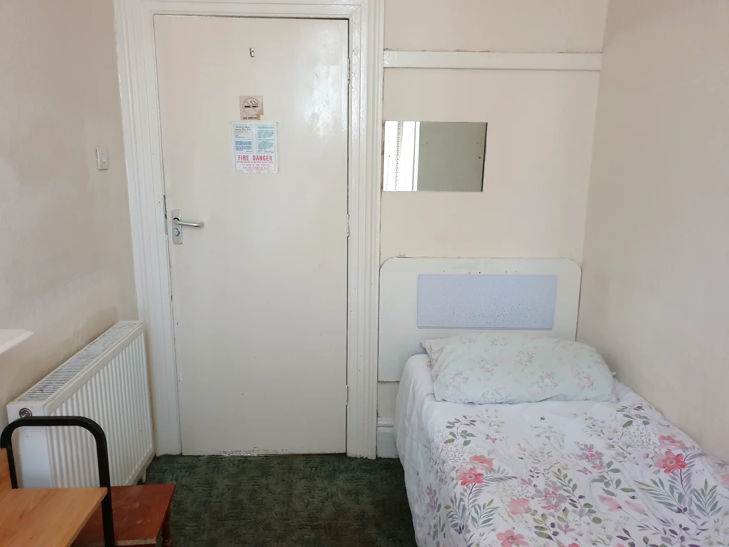 Compact single guest room with a single bed, storage and washbasin